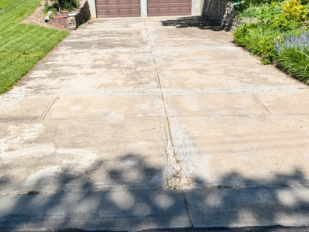 Old asphalt and concrete driveway cracks